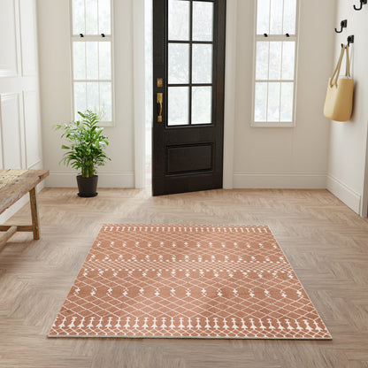 Rectangular terracotta rug with white geometric diamond lattice pattern in a bright entryway.
