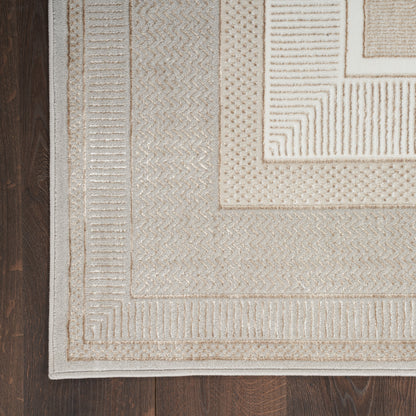 Beige textured rectangular area rug with layered geometric borders in cream and tan on dark wood floor