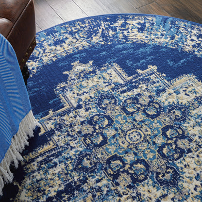 Round blue oriental rug with ivory & teal floral medallions, plush woven texture, living room decor.