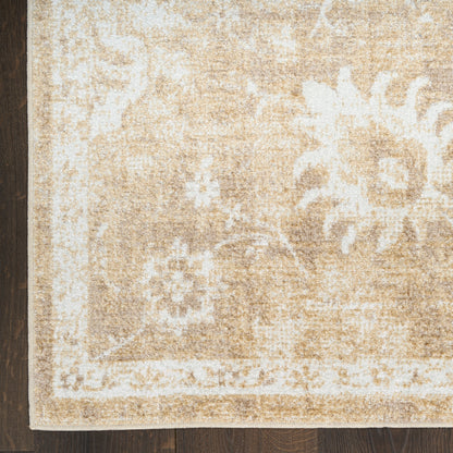 Beige distressed oriental rug with ivory floral motifs and border, laid on dark wood floor.