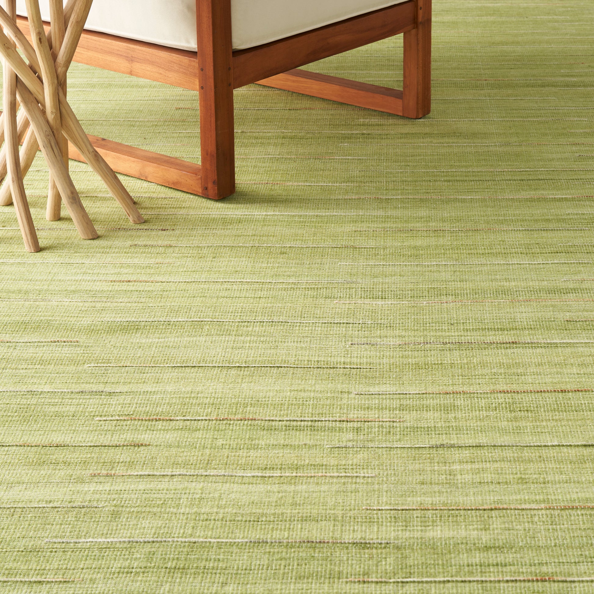 Lime-green textured rug with subtle horizontal stripes under wooden chair legs.