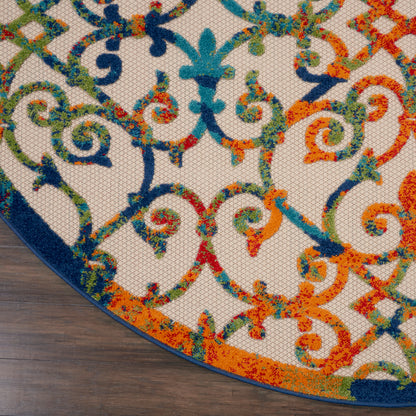 Colorful ornate area rug with blue, green, orange and red scrolling motif; curved dark blue border on wooden floor.