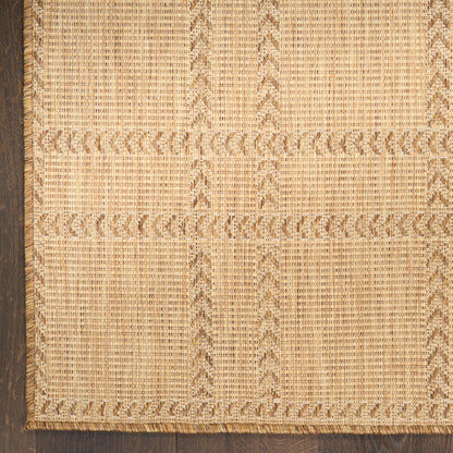 Natural beige woven jute runner rug with geometric rectangular panels and braided fringe on dark wood floor.