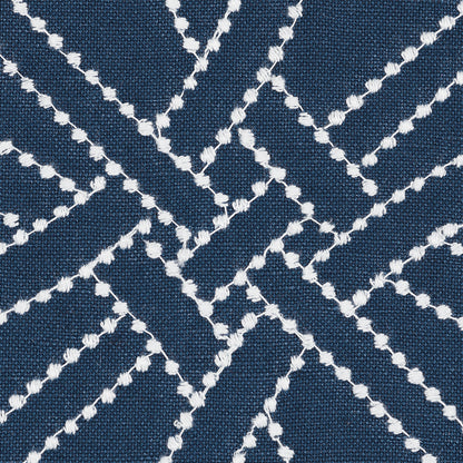 Navy blue fabric with white embroidered diamond lattice pattern; geometric texture.