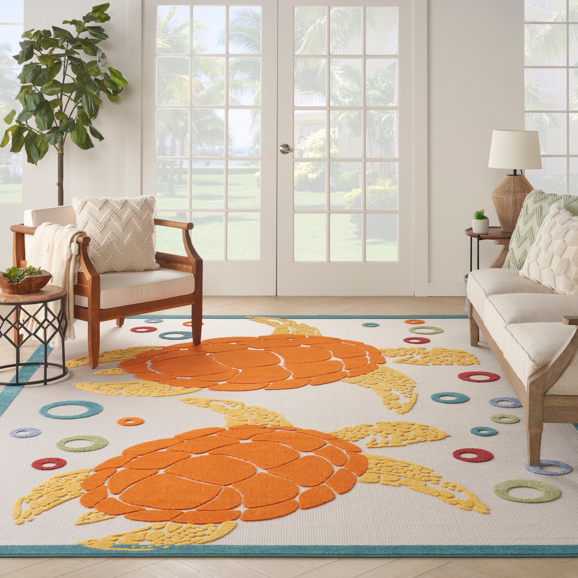 Living room with a tropical rug featuring bright orange sea-turtle shell motifs, colorful circles, beige sofa and wooden chairs.