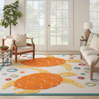 Living room with a tropical rug featuring bright orange sea-turtle shell motifs, colorful circles, beige sofa and wooden chairs.