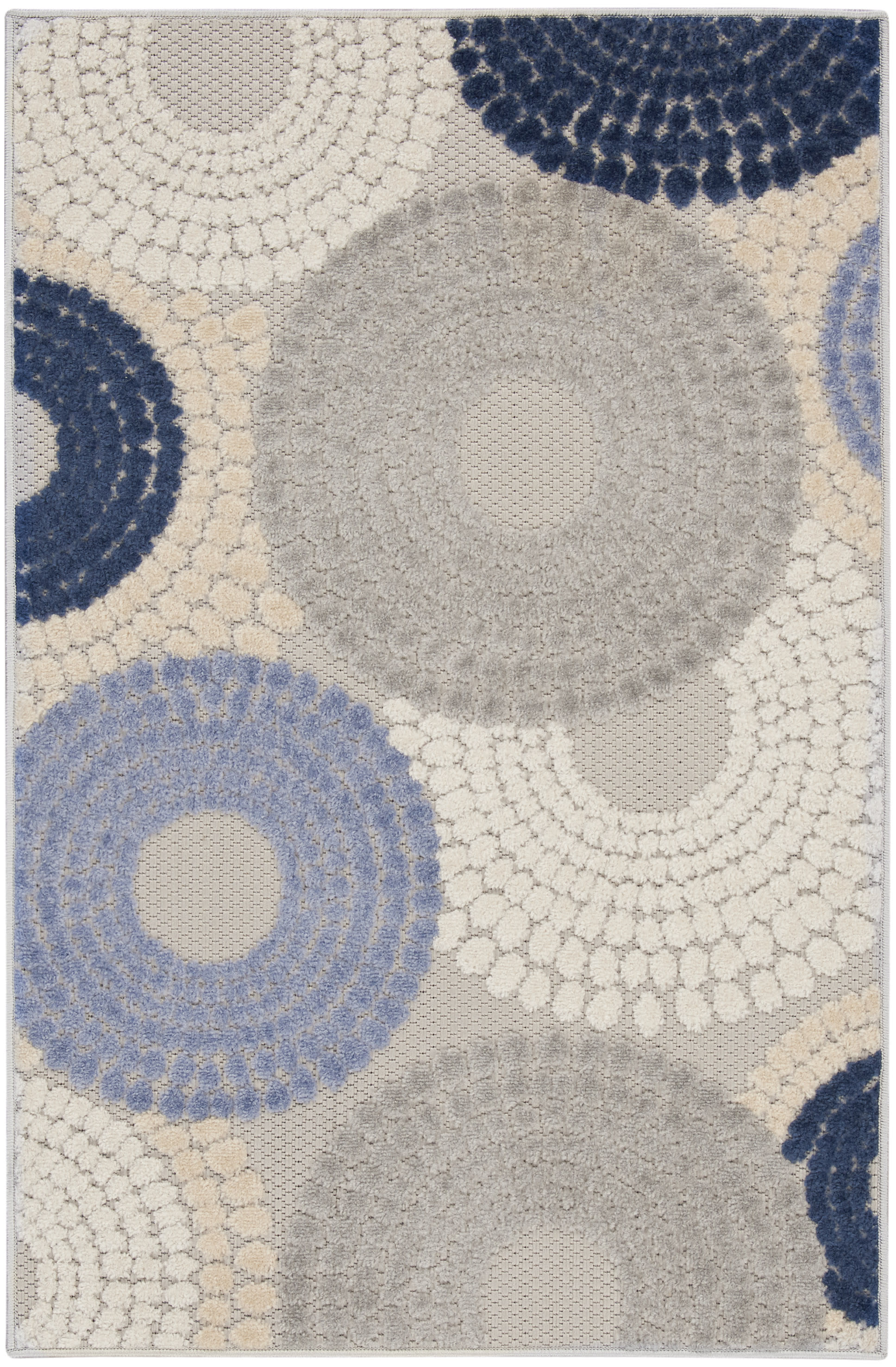 Rectangular textured shag rug with large circular concentric patterns in cream, beige, gray and navy.