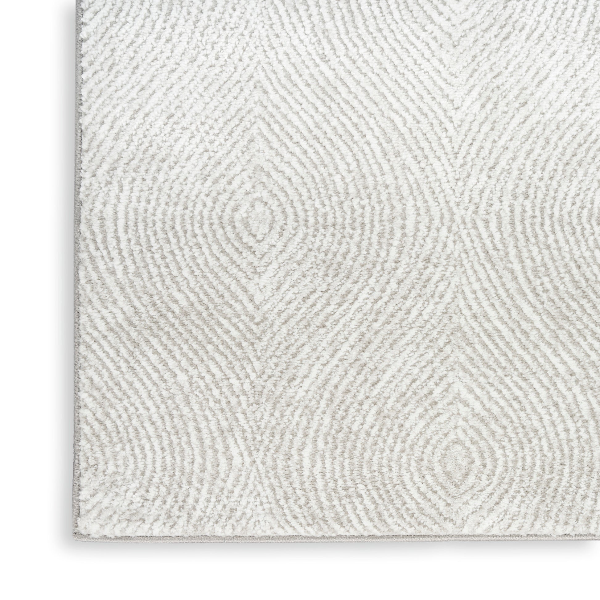 Cream textured area rug with soft shag pile and subtle circular concentric pattern, edge-bound in light gray.