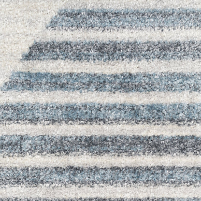 Close-up of a blue and cream striped rug with soft pile and alternating thick and thin horizontal stripes.