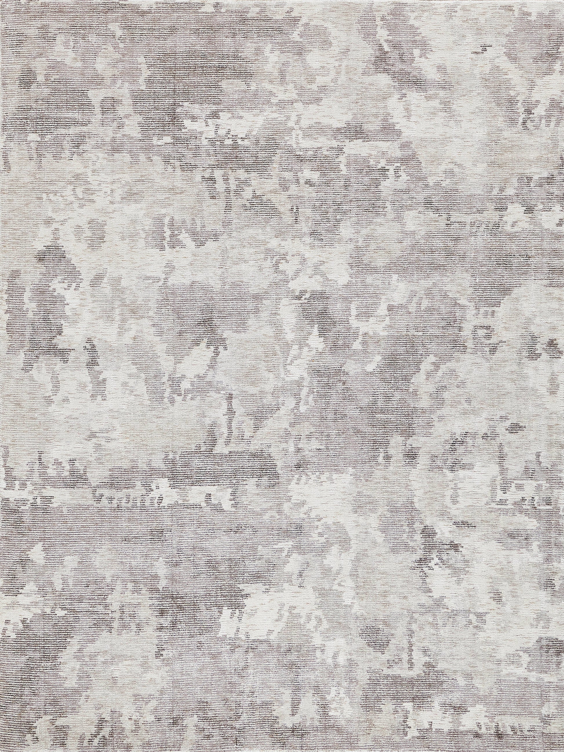 Soft neutral-toned distressed area rug with muted gray and cream abstract pattern.