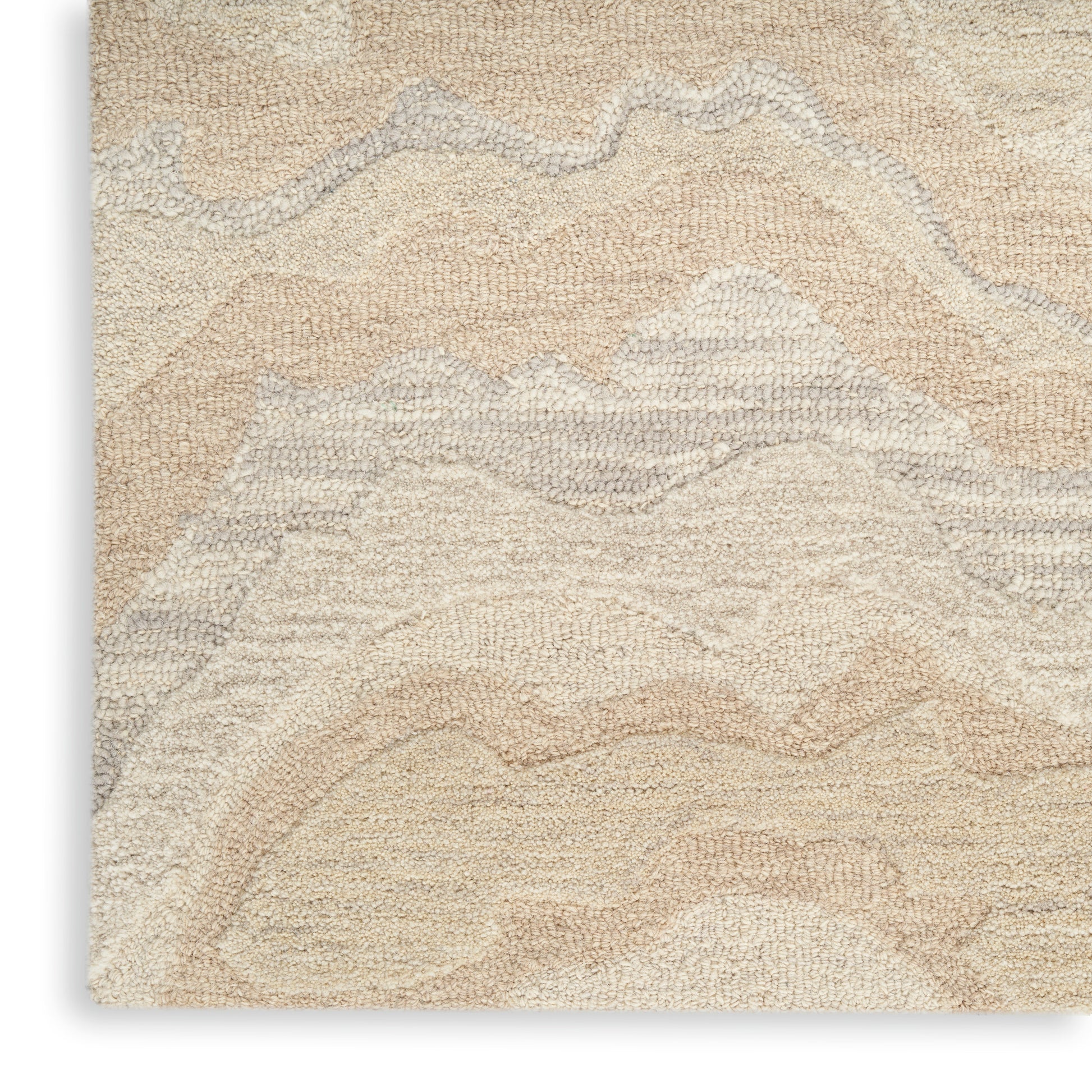 Close-up of a soft cream and beige textured area rug with an abstract wavy pattern in neutral tones.