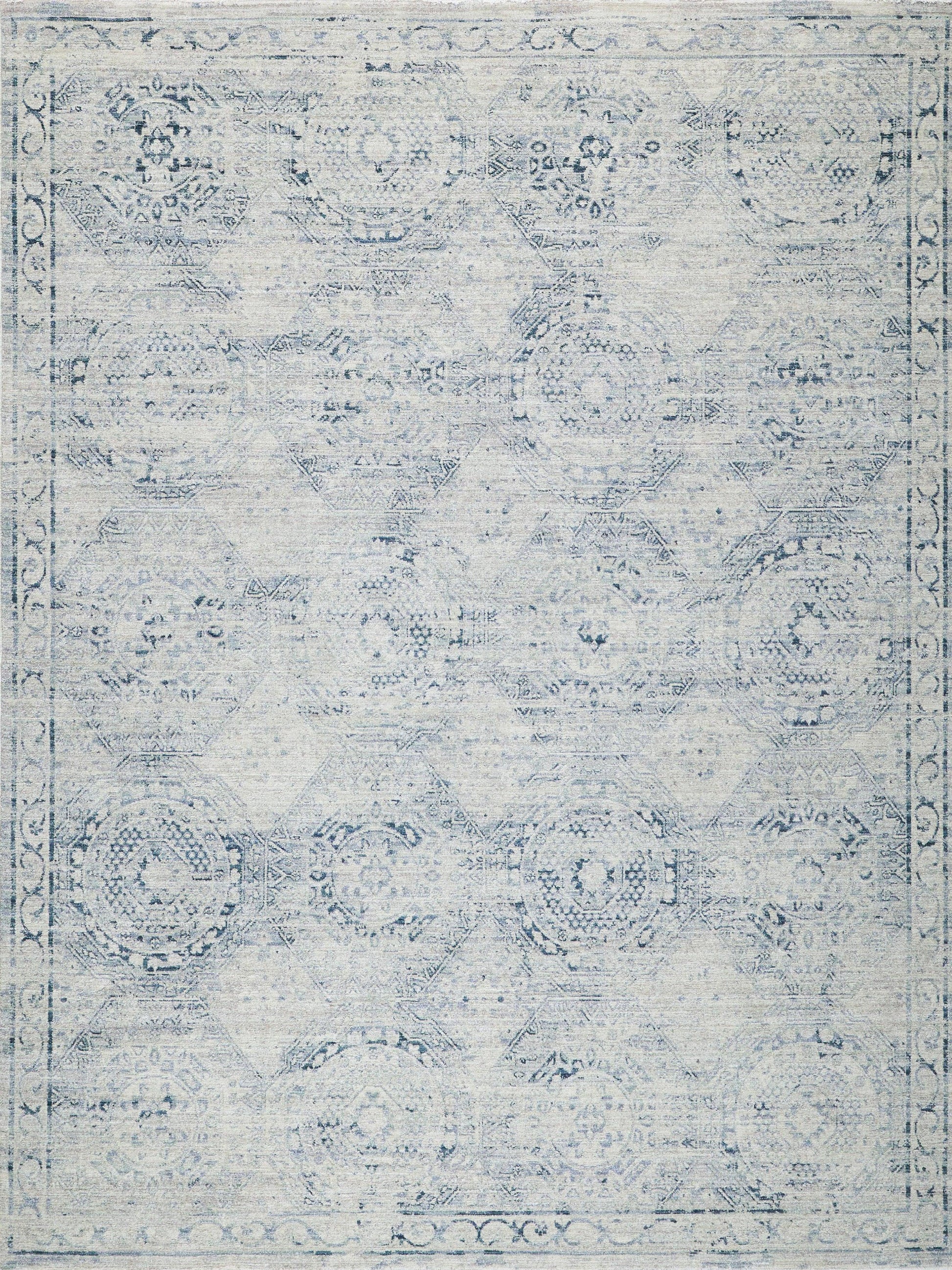 Distressed pale blue oriental rug with faded circular medallions and a decorative border.