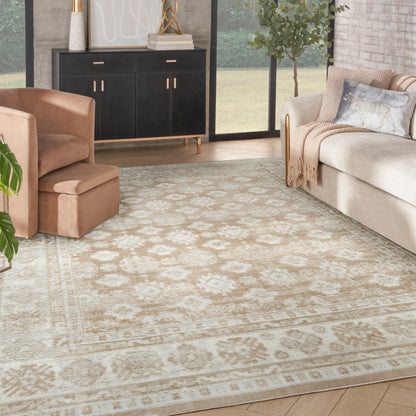 Beige ornate rug in a modern living room with a beige sofa, peach armchair, and black cabinet with gold hardware.