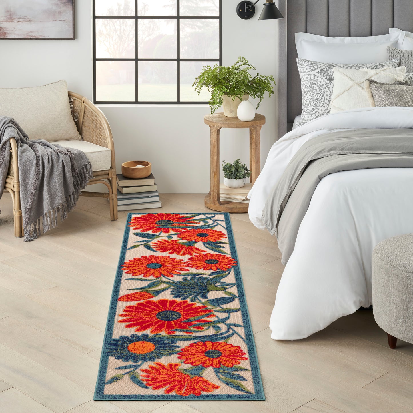 Floral outdoor runner rug with bright orange flowers and teal border, 6 ft long.
