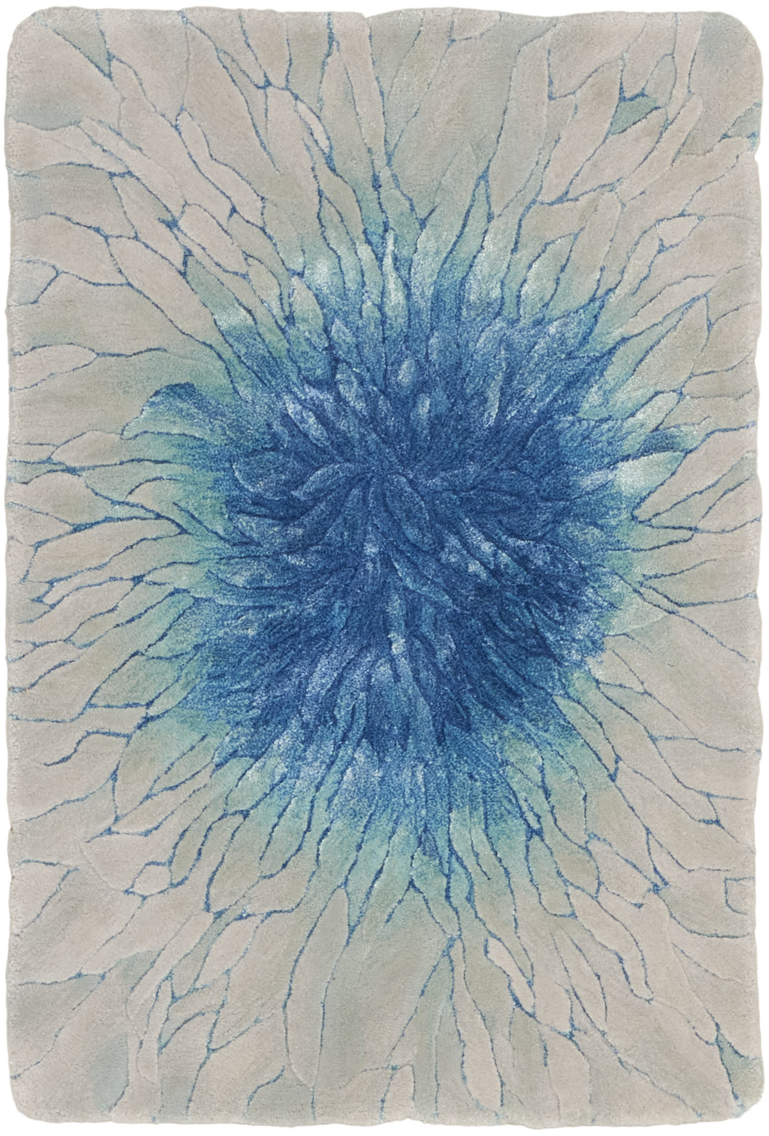 Rectangular blue burst rug on cream backdrop; plush shag with radiating blue spokes, modern coastal style.