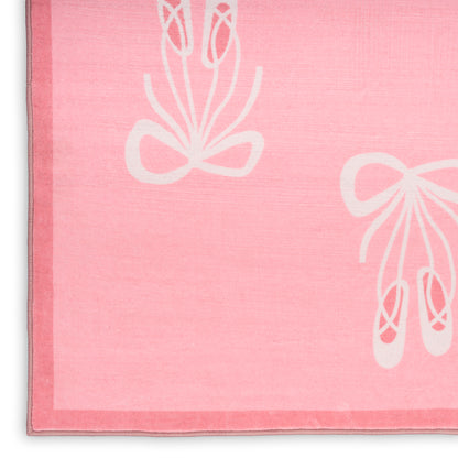 Pink kids rug with white ballet shoe and bow motifs; soft pile.