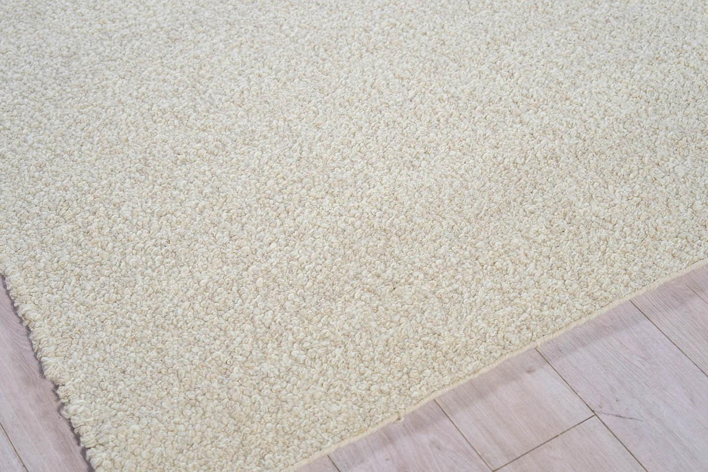Cream-beige shag rug with thick plush pile on light wood floor; rectangular living room rug.