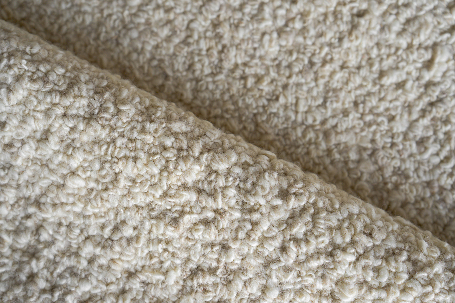 Cream indoor hand-loomed rug with a plush, curly texture.