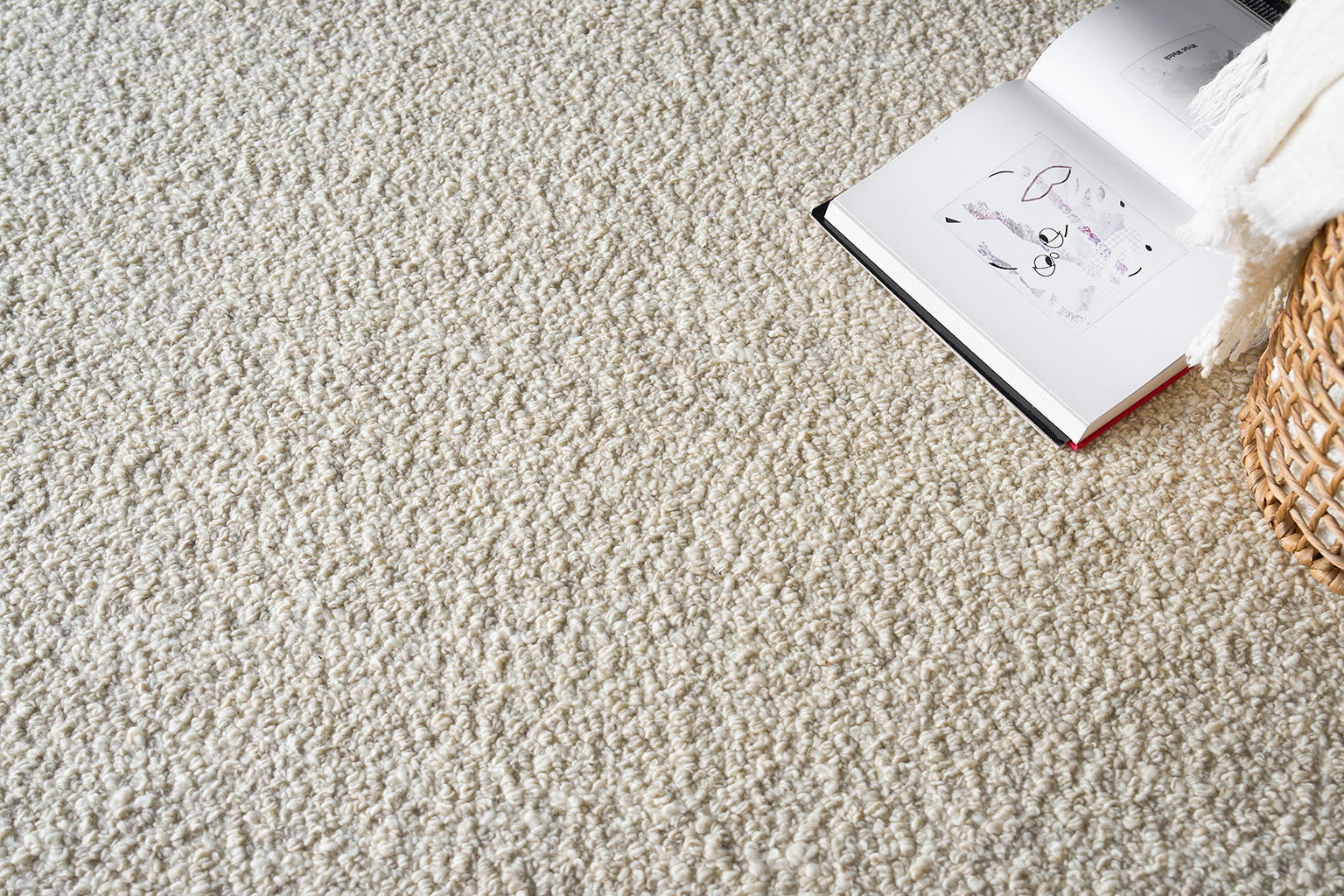 Cream loop-pile shag rug with a woven basket and an open book nearby.