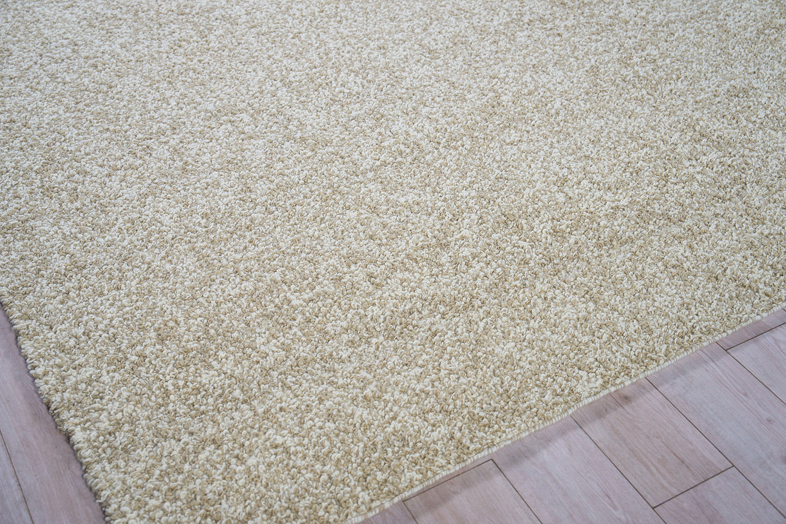 Beige shag rug with thick plush pile on light wood floor; cozy, modern living room or bedroom accent.