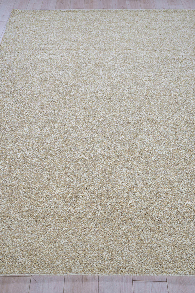 Beige high-pile shag rug in cream tones on light wood floor; rectangular living room area rug.
