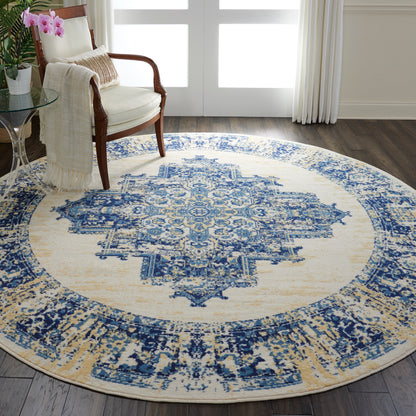 Round blue and ivory oriental rug with a central medallion in a living room beside a wooden armchair.