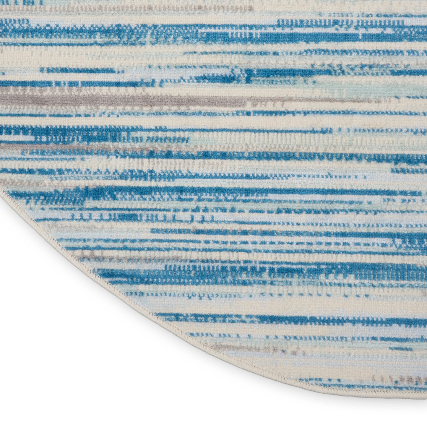 Round cream rug with blue abstract horizontal stripes; woven textile, casual coastal style.