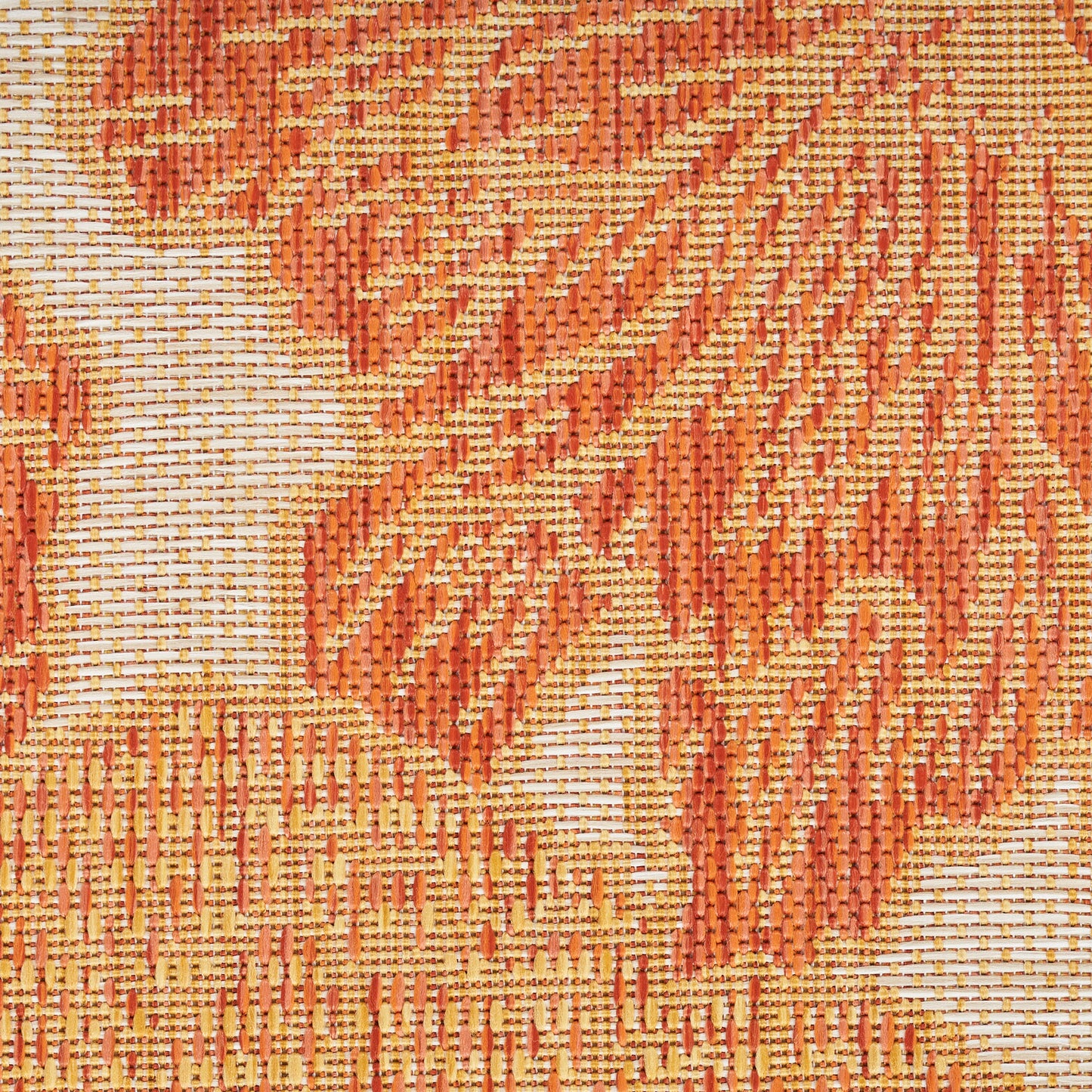 Close-up of orange jacquard woven rug with beige background and damask floral pattern.
