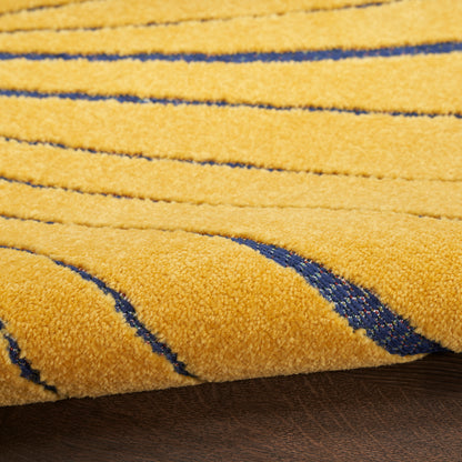 Close-up of a bright yellow tufted rug with navy curved stripes and soft textured pile.