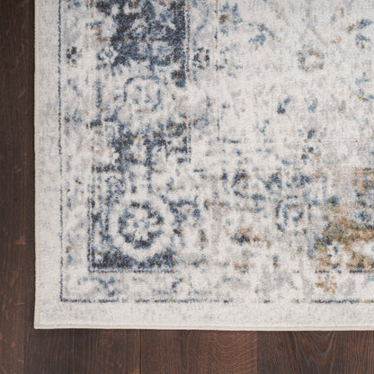 Distressed blue & ivory oriental-style area rug with subtle border on dark wood floor.