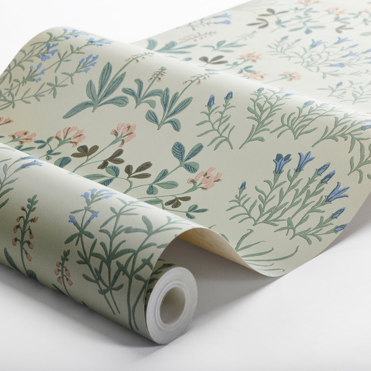 Beige botanical wallpaper with pastel blue, green, & pink herb-and-flower motifs, rolled up.