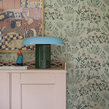 Floral wallpaper with a vintage-style mineral-inspired blue pattern on the wall beside a white cabinet.