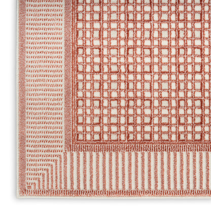 Terracotta and cream woven rug with square-grid center and striped outer borders.