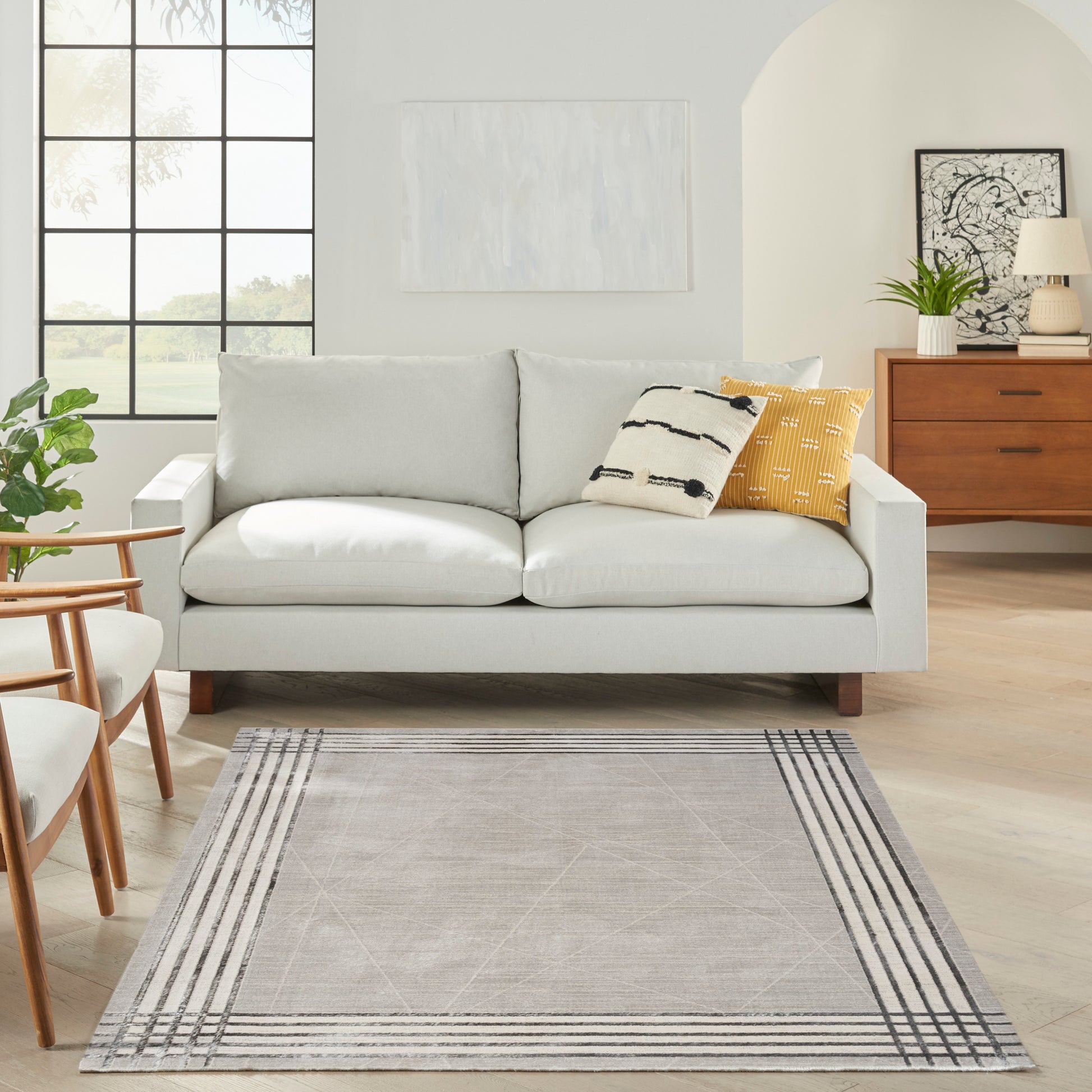 Light gray rug with a striped border in a bright living room.