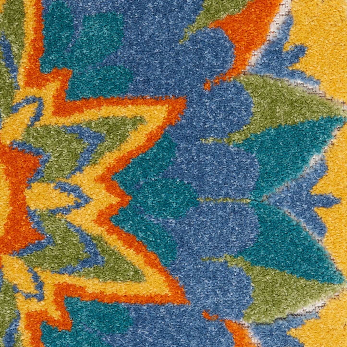 Close-up of a colorful abstract-patterned rug with orange zigzag outlines and blue, teal, green, yellow shapes.