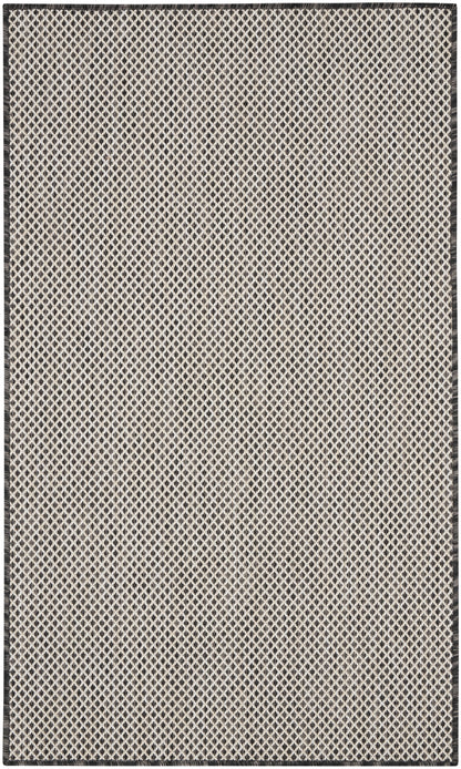 Beige flat-weave rug with tiny black diamond lattice pattern and dark border, rectangular.