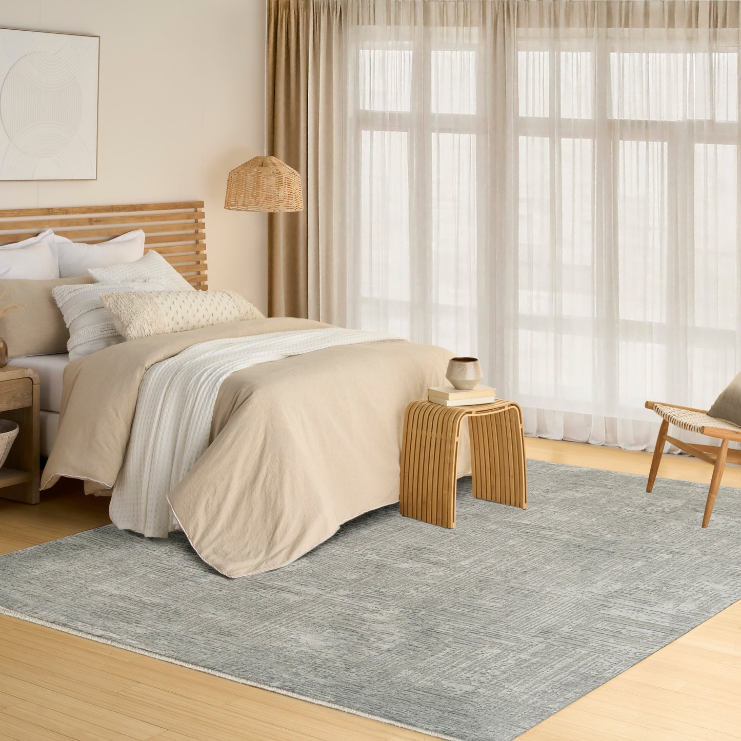 Neutral-toned bedroom with beige duvet, light wood bed frame, rattan pendant lamp, gray rug, sheer curtains.