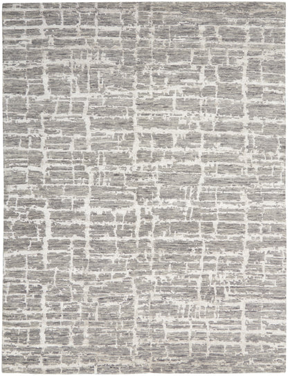 Gray and white rug with irregular block pattern, textured flat-weave for modern neutral decor.