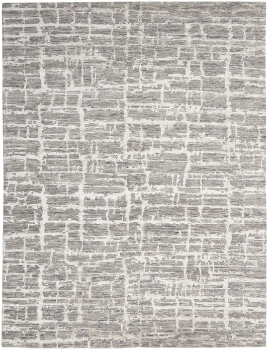 Gray and white rug with irregular block pattern, textured flat-weave for modern neutral decor.