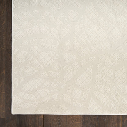 Cream textured area rug with subtle abstract geometric pattern on a dark wood floor.