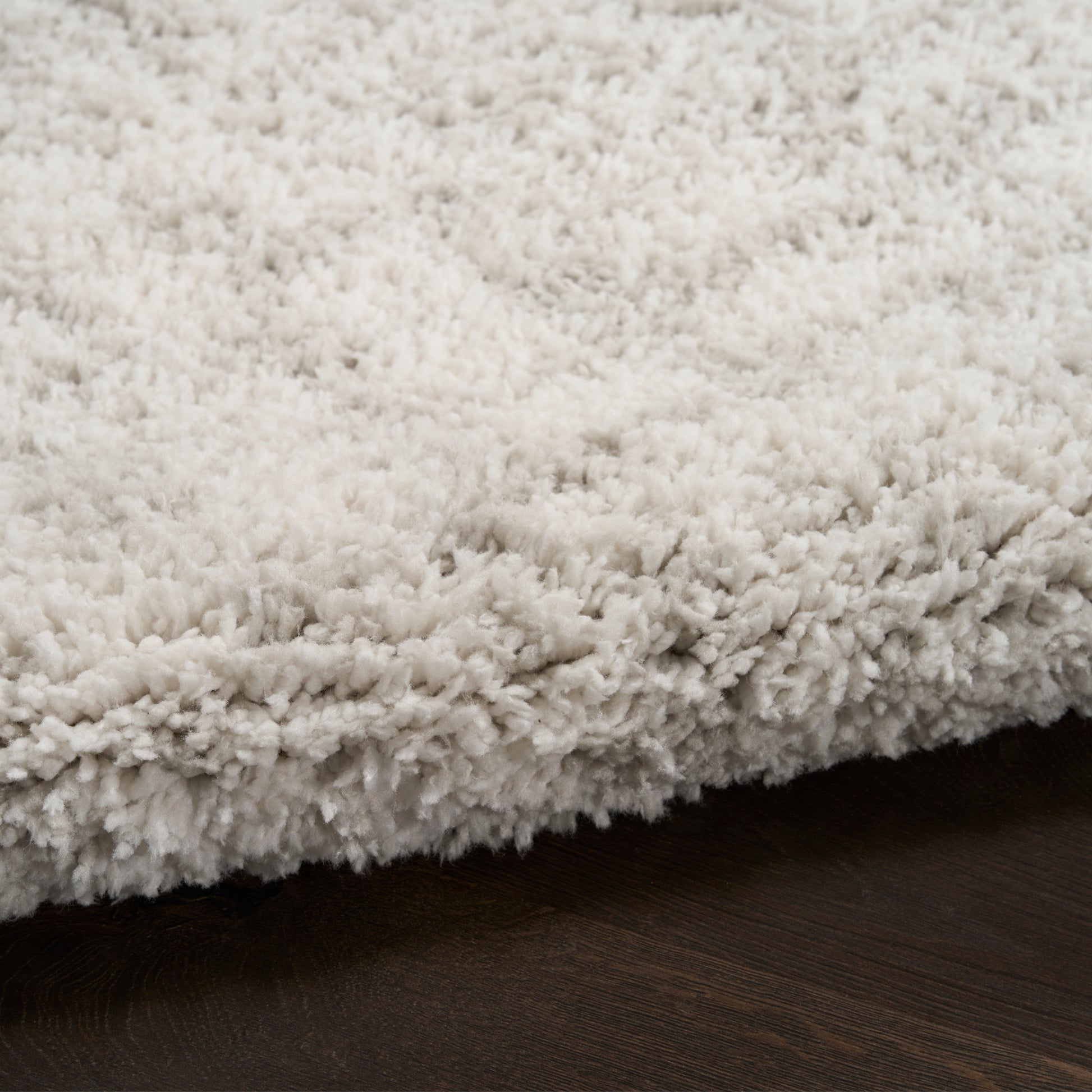 Cream shag rug with soft, thick plush pile on dark wood floor.