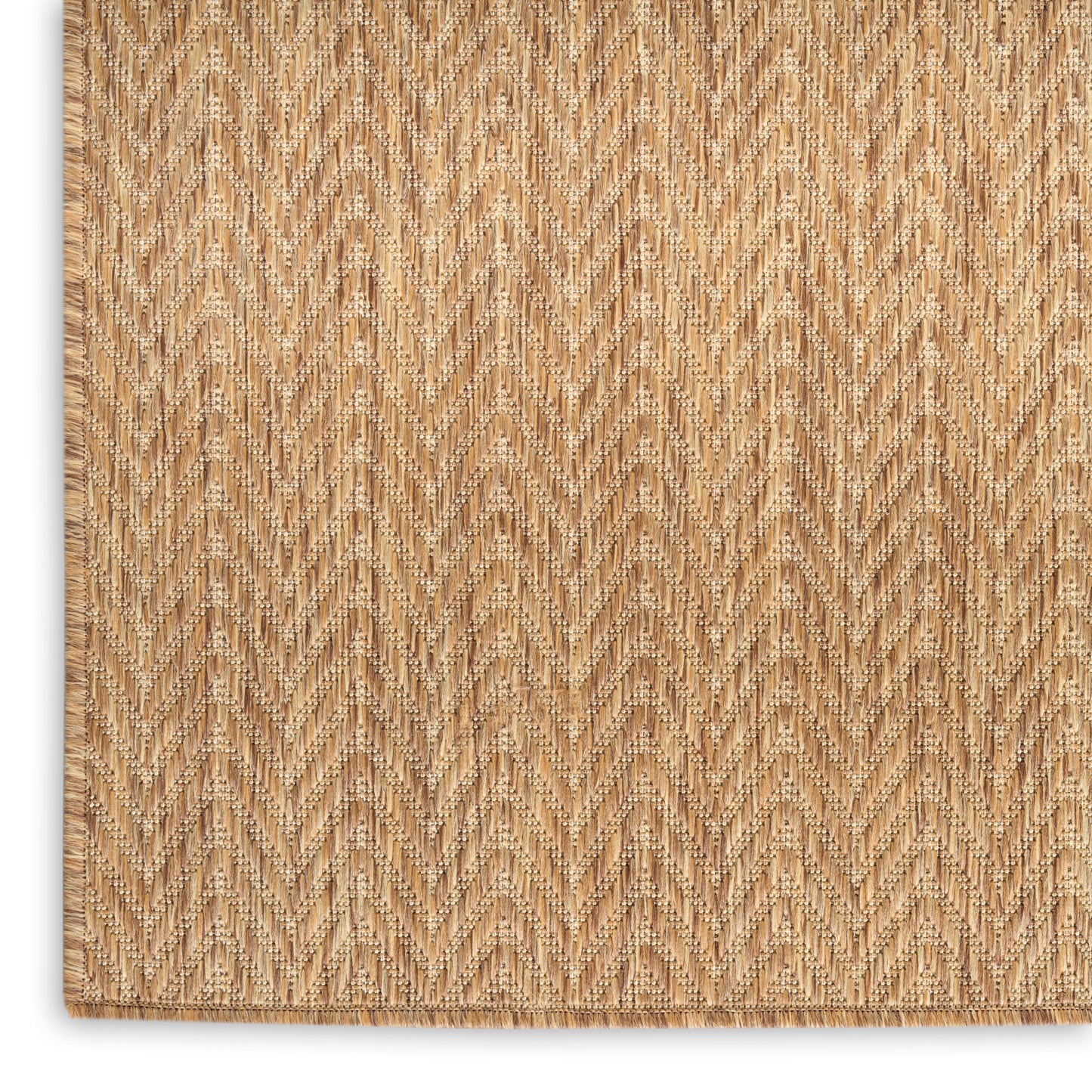 Natural tan jute rug with chevron herringbone weave and fringe edge; rustic coastal living room rug.