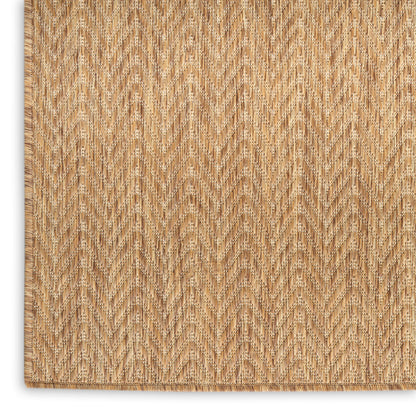 Natural tan jute rug with chevron herringbone weave and fringe edge; rustic coastal living room rug.