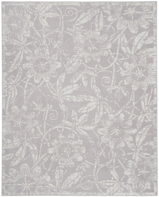 Light gray area rug featuring an allover white floral damask pattern and woven texture.