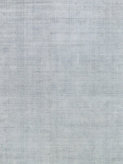 Gray-blue hand-loomed indoor rug texture; close-up of woven fabric.