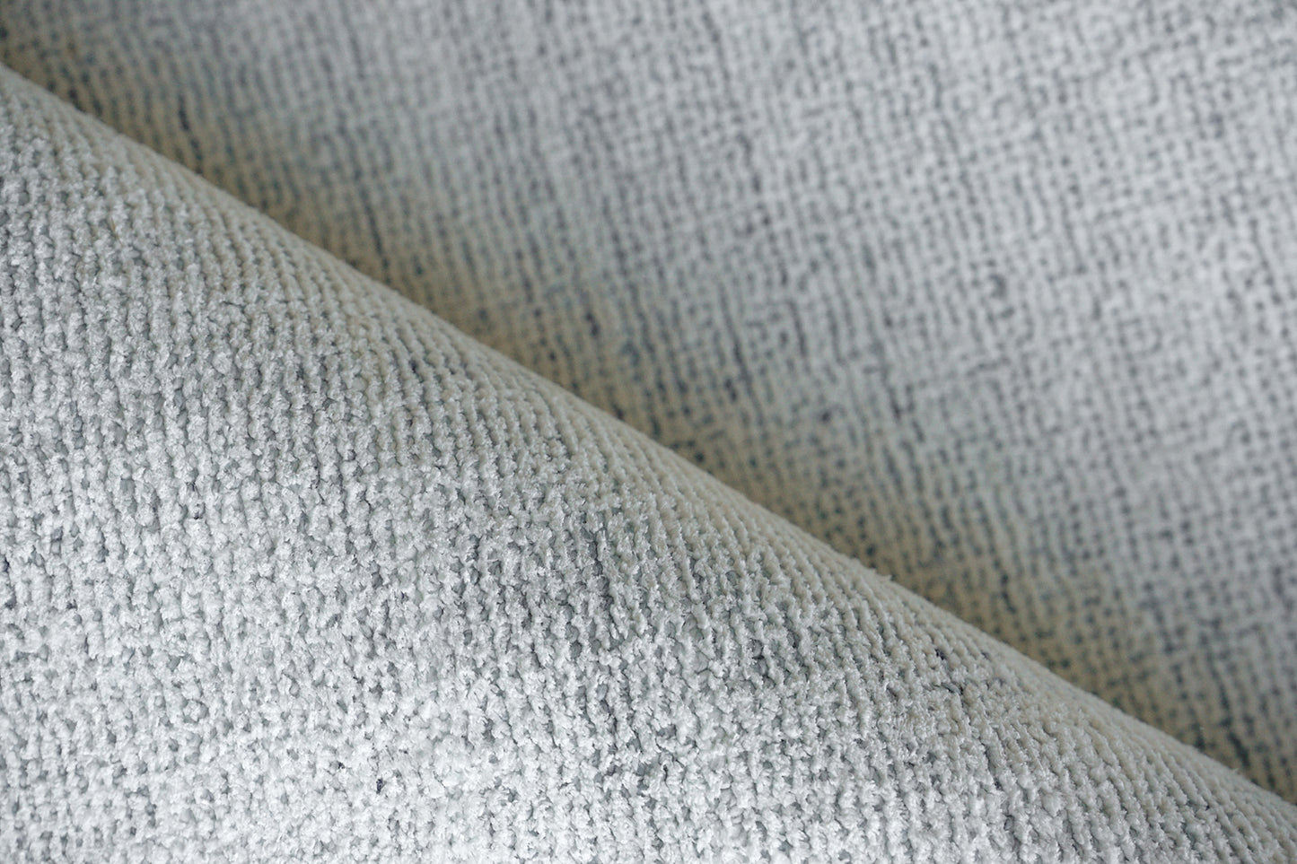 Light gray boucle rug, close-up of a textured woven surface, size 2' x 3'.