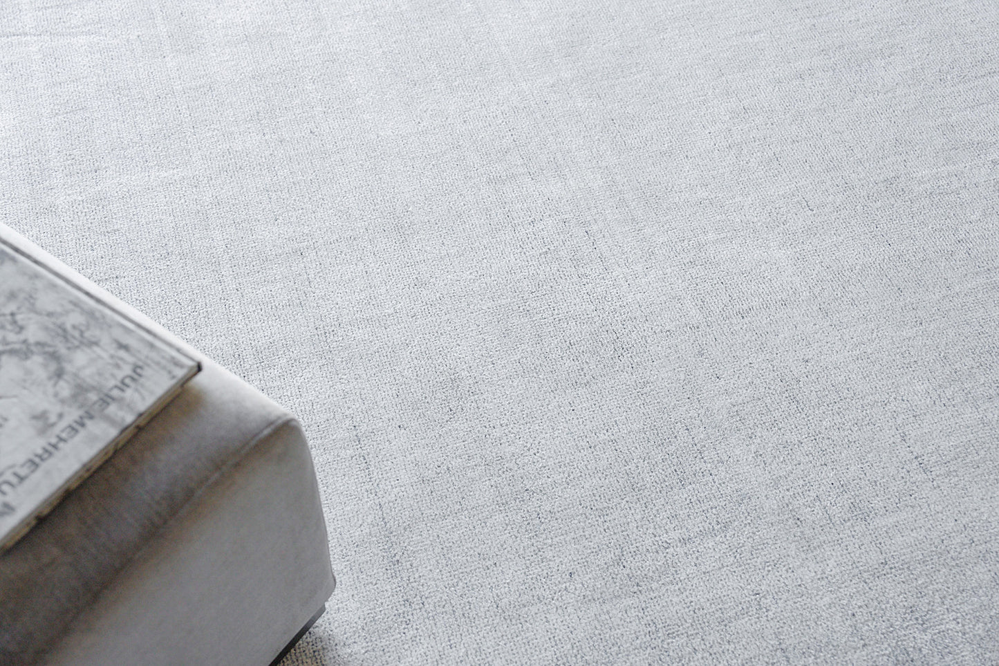 Rectangular light gray rug with a pale textured surface.