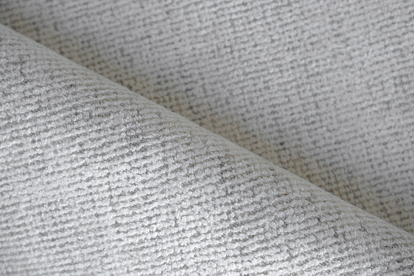 Gray linen-like woven rug with subtle texture and soft drape.