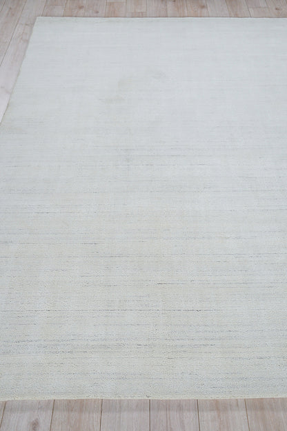 Rectangular pale gray rug (2' x 3') with subtle tonal texture on light wood floor