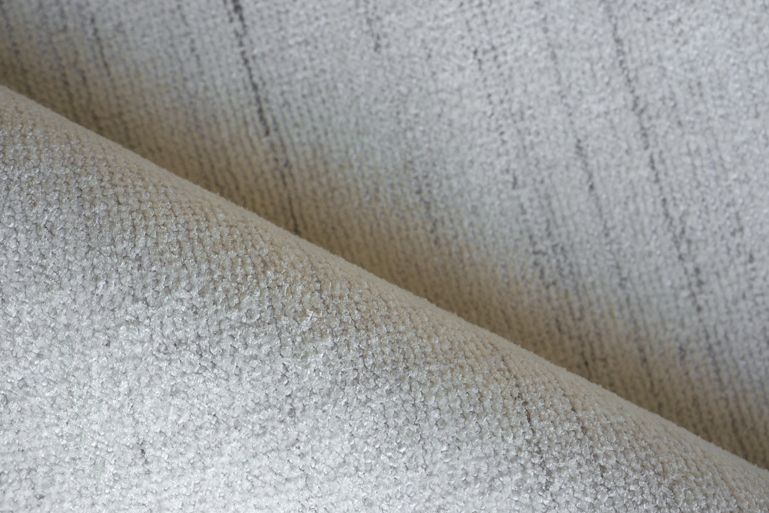 Beige hand-loomed rug with woven texture and soft folds, 12' x 15'.